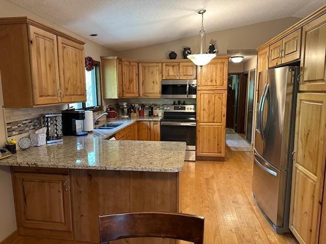 26722 Eisenmen Dr, Leonard, MN 56652 - kitchen with appliances with stainless steel finishes, lofted ceiling, a sink, a peninsula, and tasteful backsplash