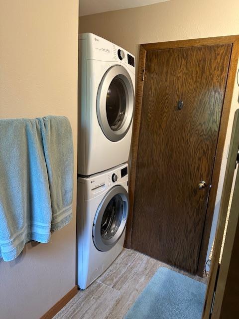 26722 Eisenmen Dr, Leonard, MN 56652 - washroom featuring stacked washer / dryer, light wood-type flooring, and baseboards