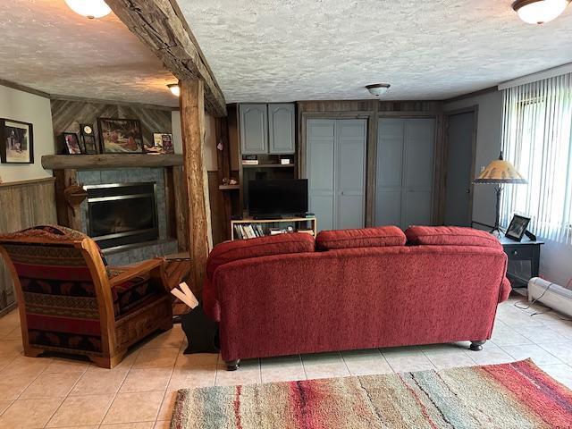 26722 Eisenmen Dr, Leonard, MN 56652 - living area featuring light tile patterned floors, a textured ceiling, a fireplace, and wood walls