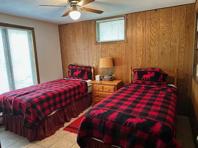 26722 Eisenmen Dr, Leonard, MN 56652 - bedroom with wooden walls, light tile patterned flooring, and a ceiling fan