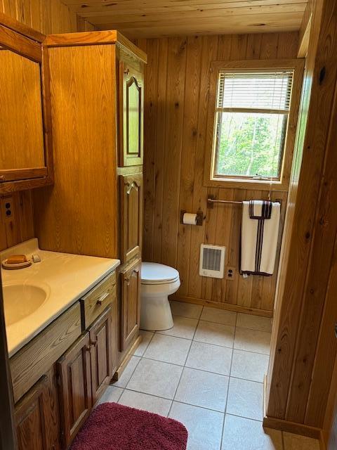 26722 Eisenmen Dr, Leonard, MN 56652 - bathroom with vanity, wood ceiling, toilet, wooden walls, and tile patterned floors
