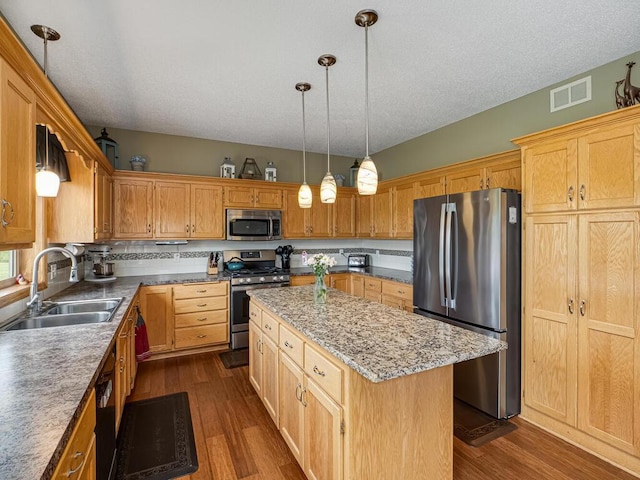 9368 188th Ave NW, Nowthen, MN 55330 - kitchen with appliances with stainless steel finishes, a kitchen island, dark wood-style flooring, decorative light fixtures, and a textured ceiling