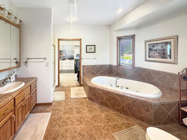 16 Pheasant Dr, Mason Twp, MN 56172 - bathroom featuring a tub with jets, vanity, a walk in closet, and tile patterned floors