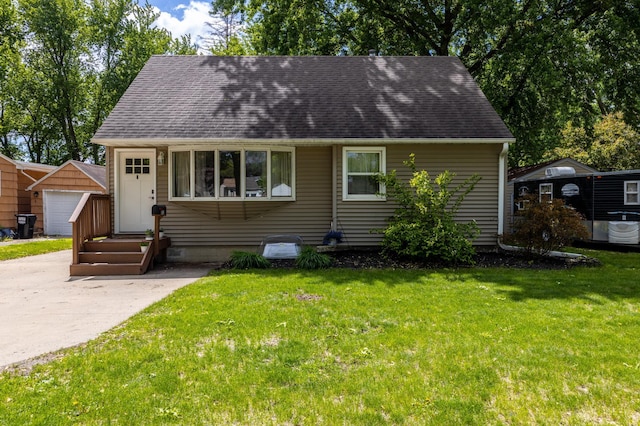 802 19th St SW, Austin, MN 55912 - view of front of home with an outbuilding, roof with shingles, and a front lawn
