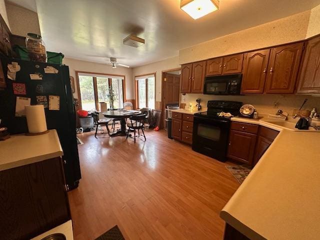 6563 Sandy Ln, Biwabik Twp, MN 55741 - kitchen with black appliances, light countertops, light wood-style floors, and a ceiling fan