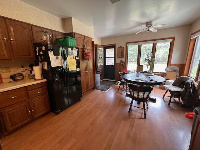 6563 Sandy Ln, Biwabik Twp, MN 55741 - kitchen with black refrigerator with ice dispenser, ceiling fan, light wood-type flooring, light countertops, and brown cabinets