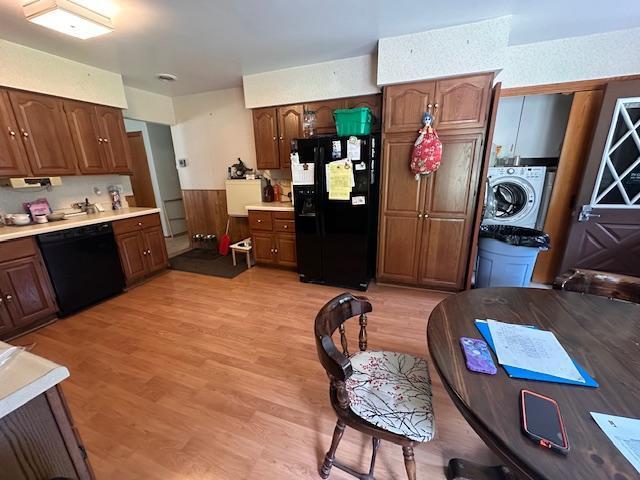 6563 Sandy Ln, Biwabik Twp, MN 55741 - kitchen with black appliances, washer / dryer, light countertops, and light wood finished floors