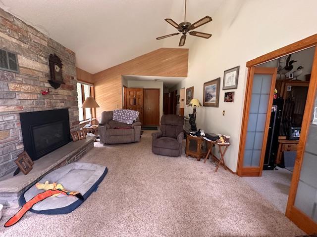 6563 Sandy Ln, Biwabik Twp, MN 55741 - living area with carpet, ceiling fan, a stone fireplace, and high vaulted ceiling