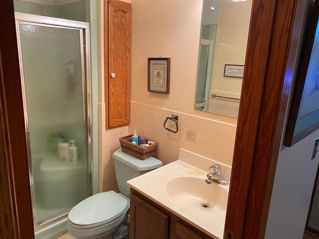 6563 Sandy Ln, Biwabik Twp, MN 55741 - bathroom featuring toilet, a stall shower, vanity, tile walls, and a wainscoted wall