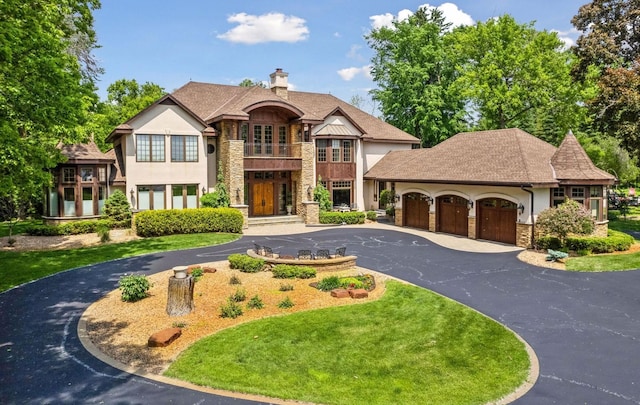 1910 Shoreline Dr, Orono, MN 55391 - view of front facade with stone siding, a balcony, curved driveway, stucco siding, and an attached garage
