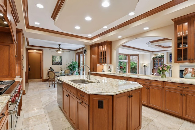 1910 Shoreline Dr, Orono, MN 55391 - kitchen featuring a raised ceiling, crown molding, arched walkways, brown cabinetry, and an island with sink