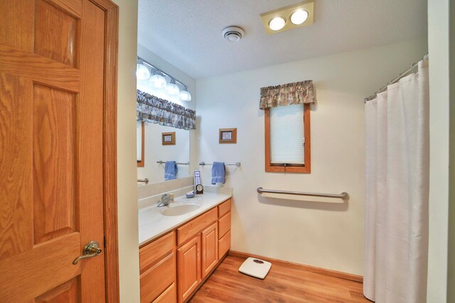 909 Lilac Ln, Little Falls, MN 56345 - full bathroom featuring wood finished floors, vanity, baseboards, and curtained shower