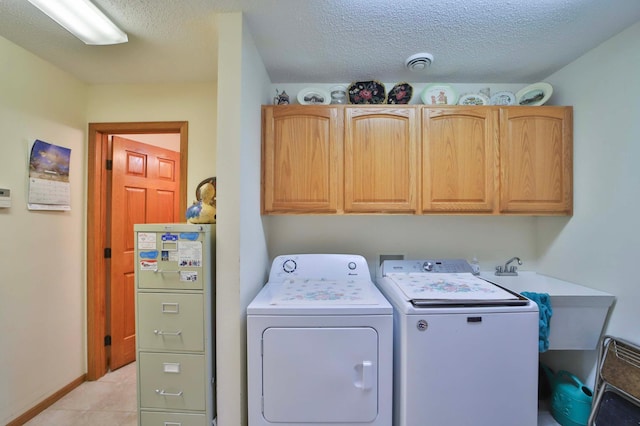 909 Lilac Ln, Little Falls, MN 56345 - washroom featuring cabinet space, washing machine and dryer, a textured ceiling, and light tile patterned floors