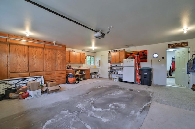 909 Lilac Ln, Little Falls, MN 56345 - garage featuring freestanding refrigerator, a garage door opener, and a workshop area