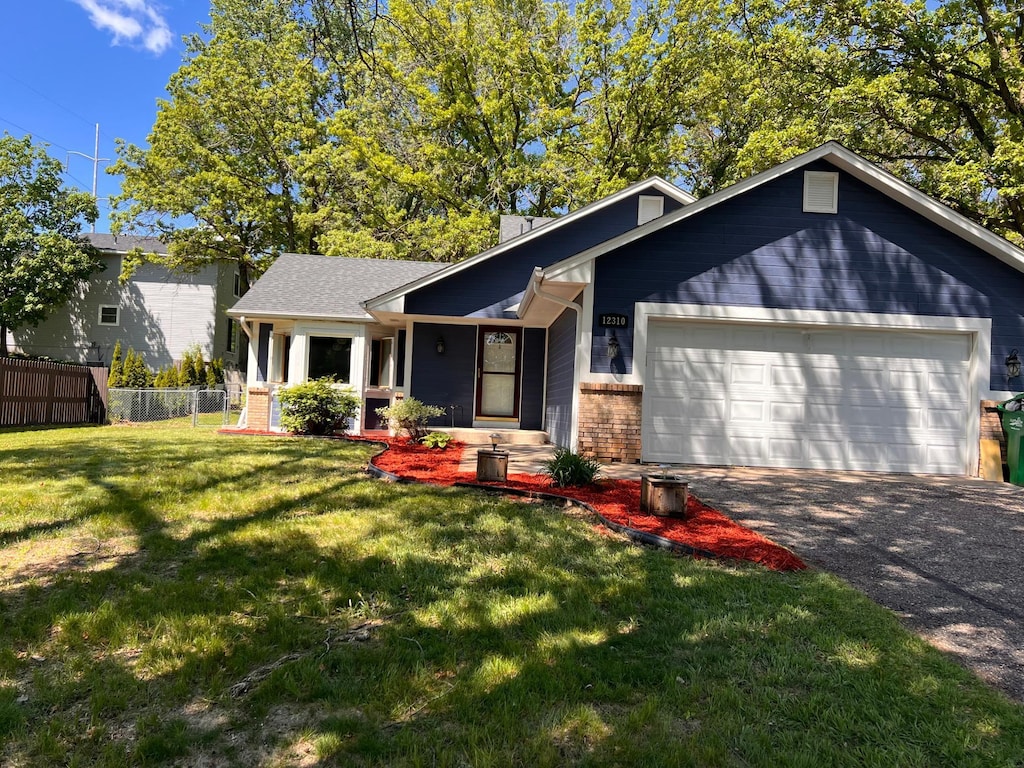 12310 Flintwood St NW, Coon Rapids, MN 55448 - view of front of home featuring a garage, driveway, brick siding, and a chimney