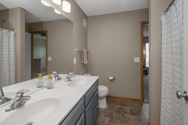 5150 Fairpoint Dr N, Hugo, MN 55038 - bathroom with double vanity, baseboards, and toilet