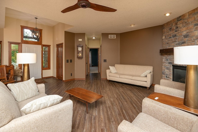 2373 Tee Time Rd SE, Rochester, MN 55904 - living area featuring a stone fireplace, wood finished floors, ceiling fan, baseboards, and a textured ceiling