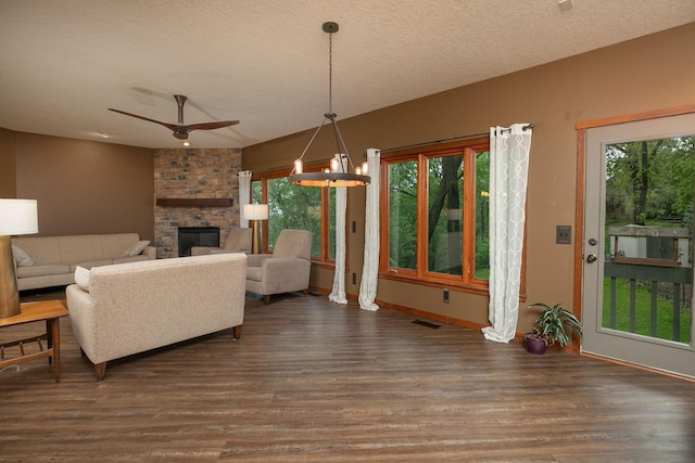 2373 Tee Time Rd SE, Rochester, MN 55904 - living area featuring wood finished floors, a stone fireplace, a textured ceiling, a ceiling fan, and baseboards