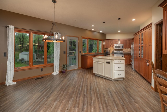 2373 Tee Time Rd SE, Rochester, MN 55904 - kitchen featuring stainless steel appliances, dark wood-type flooring, decorative backsplash, baseboards, and brown cabinetry