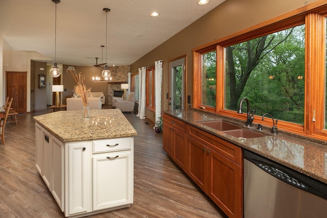 2373 Tee Time Rd SE, Rochester, MN 55904 - kitchen with stainless steel dishwasher, a sink, open floor plan, wood finished floors, and light stone countertops
