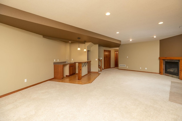 2373 Tee Time Rd SE, Rochester, MN 55904 - unfurnished living room with bar with sink, baseboards, light colored carpet, recessed lighting, and a tile fireplace