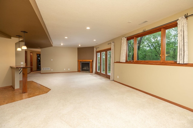 2373 Tee Time Rd SE, Rochester, MN 55904 - unfurnished living room featuring baseboards, recessed lighting, carpet, a fireplace, and healthy amount of natural light