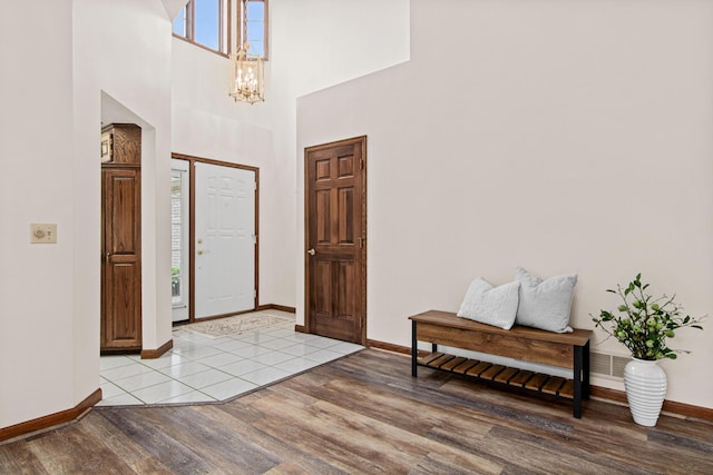 1263 Silverthorn Dr, Shoreview, MN 55126 - entryway with light wood-style flooring, baseboards, a chandelier, and a towering ceiling