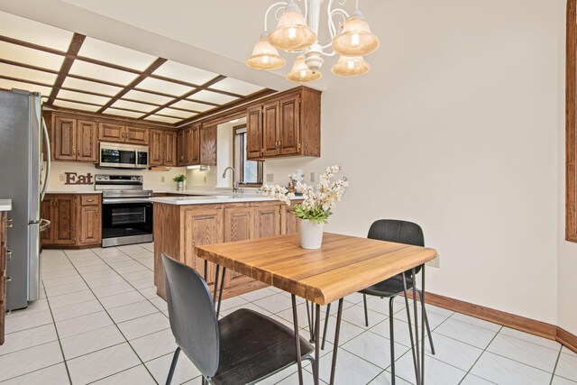 1263 Silverthorn Dr, Shoreview, MN 55126 - kitchen featuring stainless steel appliances, a chandelier, light countertops, light tile patterned floors, and baseboards