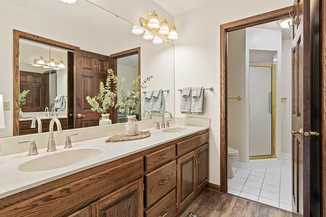 1263 Silverthorn Dr, Shoreview, MN 55126 - bathroom with toilet, double vanity, a shower stall, and wood finished floors