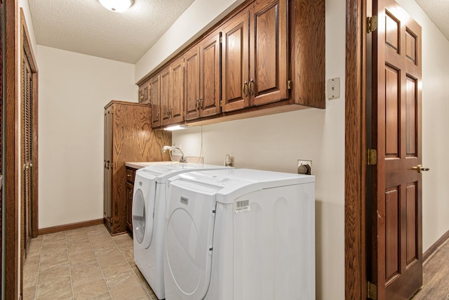 1263 Silverthorn Dr, Shoreview, MN 55126 - laundry room with cabinet space, a textured ceiling, baseboards, and separate washer and dryer