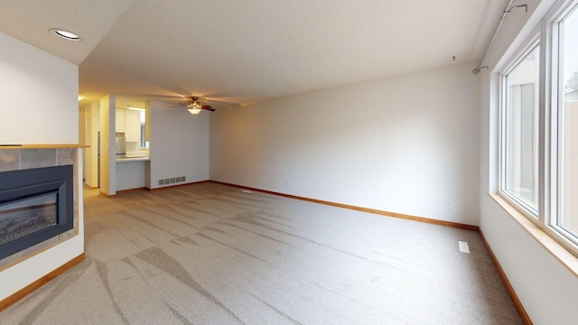 1904 Greenview Pl SW, Rochester, MN 55902 - unfurnished living room with light colored carpet, a tiled fireplace, baseboards, a ceiling fan, and recessed lighting