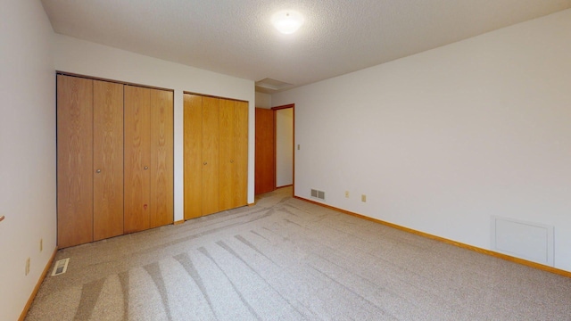 1904 Greenview Pl SW, Rochester, MN 55902 - unfurnished bedroom with light colored carpet, two closets, a textured ceiling, and baseboards