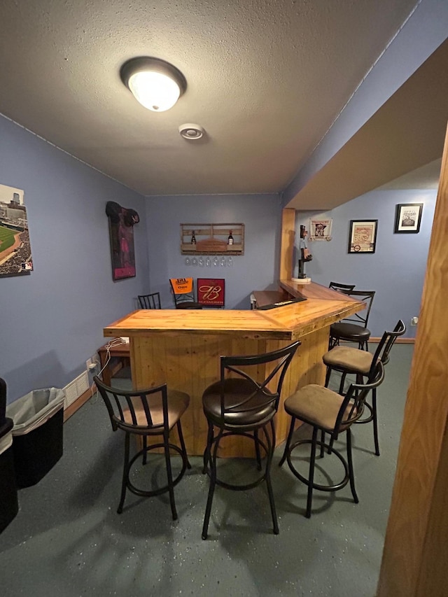 900 Pleasant Ave S, Park Rapids, MN 56470 - indoor dry bar featuring a textured ceiling, finished concrete floors, and baseboards