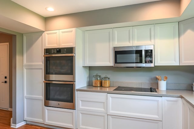 4020 Orleans Ln N, Plymouth, MN 55441 - kitchen featuring appliances with stainless steel finishes, white cabinetry, light countertops, wood finished floors, and recessed lighting