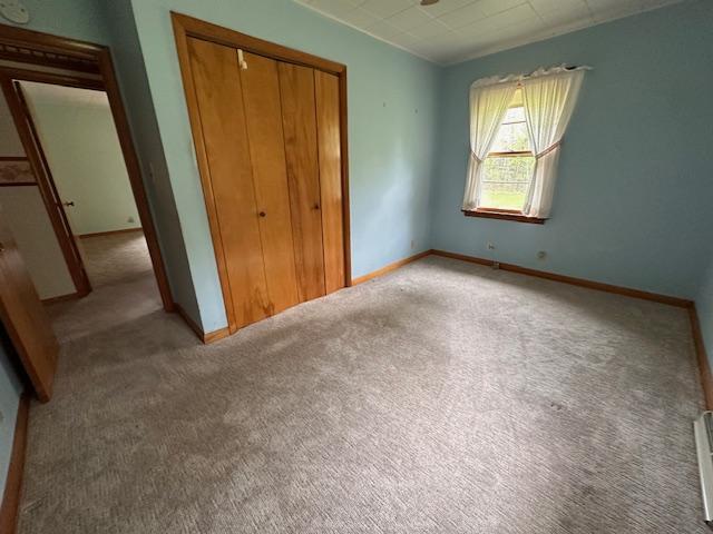 5960 Evergreen Rd, Biwabik Twp, MN 55705 - unfurnished bedroom featuring a closet, carpet floors, baseboards, and baseboard heating