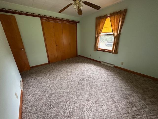 5960 Evergreen Rd, Biwabik Twp, MN 55705 - unfurnished bedroom with carpet flooring, a closet, a ceiling fan, and baseboards