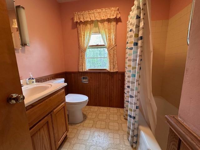 5960 Evergreen Rd, Biwabik Twp, MN 55705 - full bathroom with a wainscoted wall, toilet, vanity, tile patterned floors, and shower / tub combo with curtain