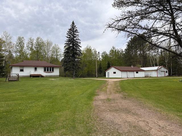 5960 Evergreen Rd, Biwabik Twp, MN 55705 - view of grassy yard with dirt driveway, a detached garage, and a deck