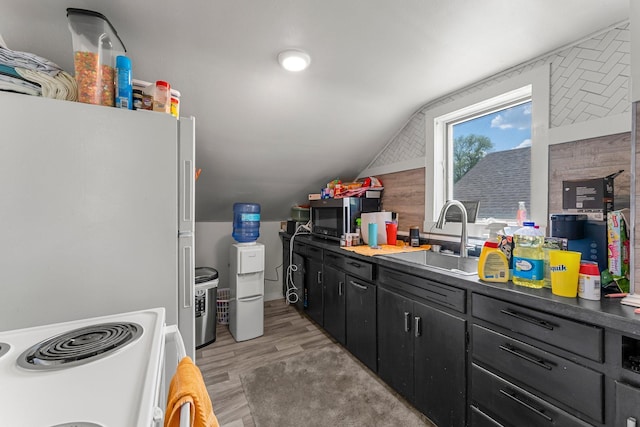 820 6th St, Montevideo, MN 56265 - kitchen with a sink, electric stove, vaulted ceiling, light wood-type flooring, and dark cabinets