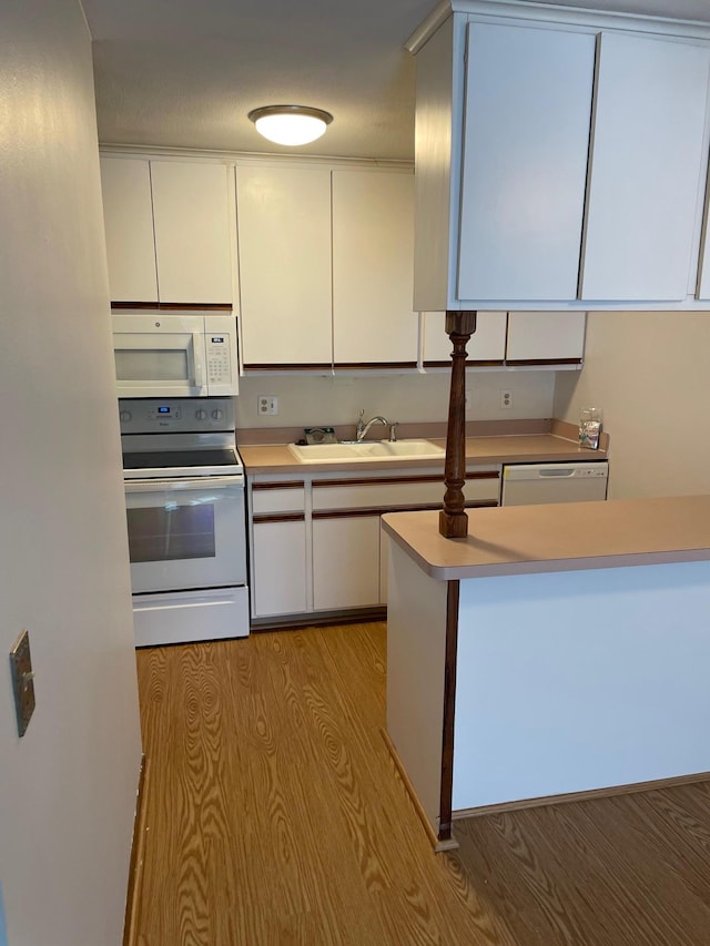 4030 15th Ave S Unit 8C, Minneapolis, MN 55407 - kitchen featuring white appliances, a sink, white cabinets, light countertops, and light wood-style flooring