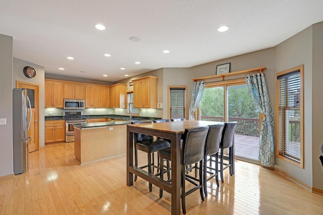 15285 Quinn St NW, Andover, MN 55304 - kitchen with stainless steel appliances, light wood-style flooring, recessed lighting, baseboards, and dark countertops