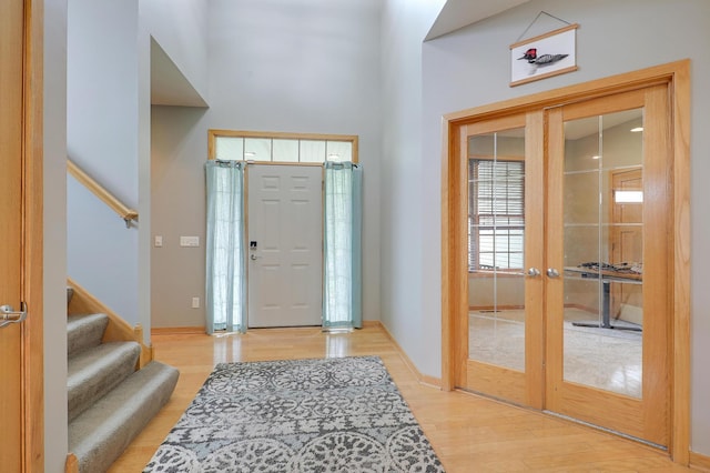 15285 Quinn St NW, Andover, MN 55304 - entrance foyer with french doors, light wood-type flooring, stairway, baseboards, and a towering ceiling