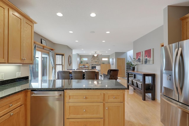 15285 Quinn St NW, Andover, MN 55304 - kitchen featuring stainless steel appliances, a peninsula, ceiling fan, light wood-style floors, and dark stone counters