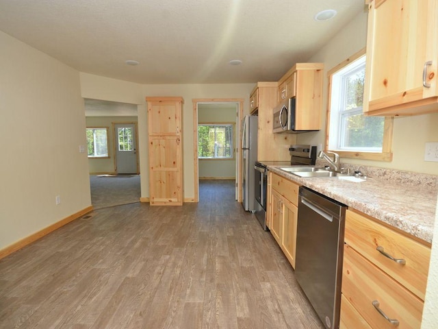 24061 US-71, Park Rapids, MN 56470 - kitchen featuring appliances with stainless steel finishes, light brown cabinetry, wood finished floors, light countertops, and a sink