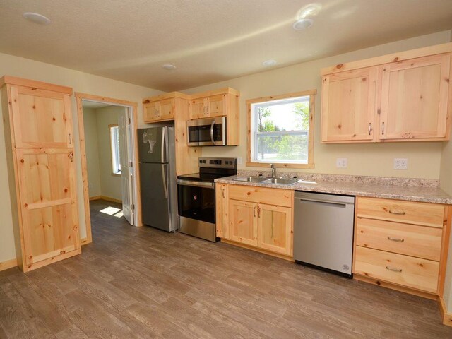 24061 US-71, Park Rapids, MN 56470 - kitchen with light brown cabinets, appliances with stainless steel finishes, a sink, and dark wood-style floors