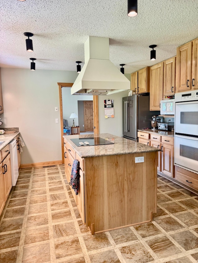 11777 State Highway 11 SE, Baudette, MN 56623 - kitchen with custom range hood, white appliances, light brown cabinetry, light stone counters, and a center island