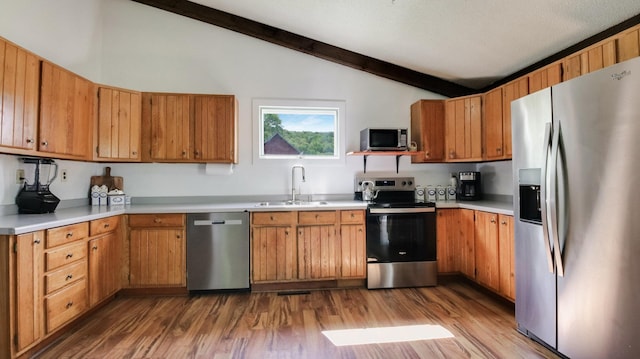 N10221 970th St, Grant Twp, WI 54730 - kitchen with stainless steel appliances, a sink, wood finished floors, light countertops, and brown cabinetry