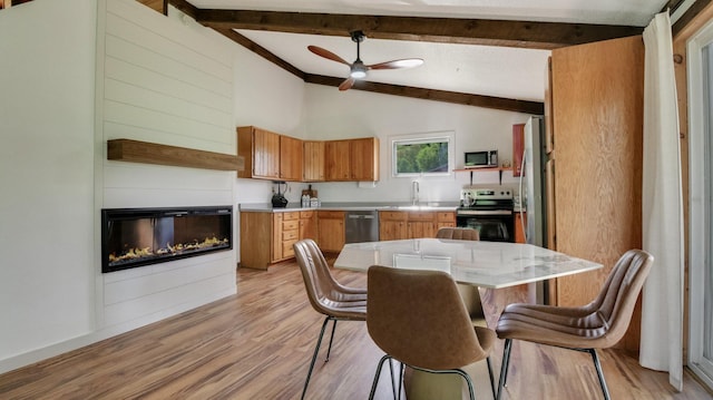 N10221 970th St, Grant Twp, WI 54730 - kitchen featuring appliances with stainless steel finishes, light countertops, light wood-style floors, a ceiling fan, and a glass covered fireplace