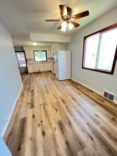 1269 Margaret St, Saint Paul, MN 55106 - unfurnished living room featuring ceiling fan, light wood-type flooring, and baseboards