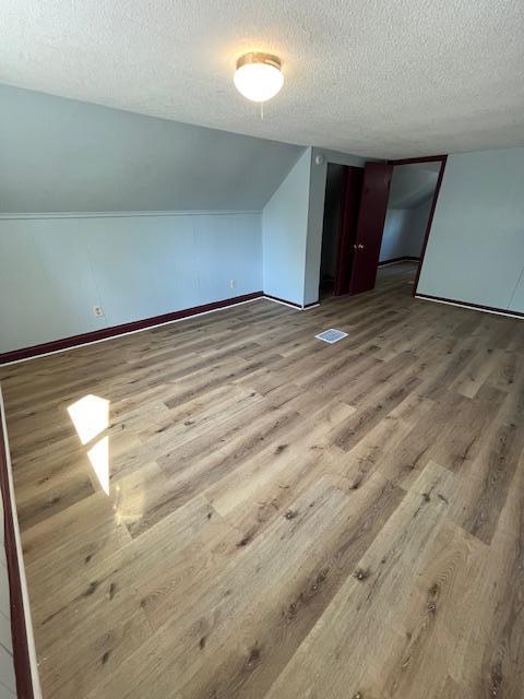 1269 Margaret St, Saint Paul, MN 55106 - bonus room with wood finished floors, a textured ceiling, and baseboards